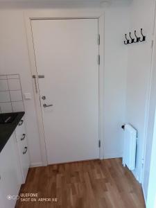 a white door in a kitchen with a wooden floor at Kalmarapartment in Kalmar