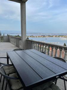 a picnic table on a balcony with a view of the ocean at Apartman Ivanica in Lukoran