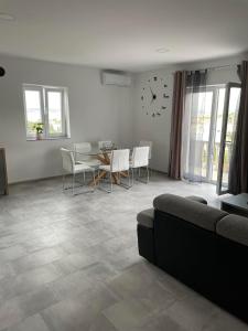 a living room with a couch and a table and chairs at Apartman Ivanica in Lukoran