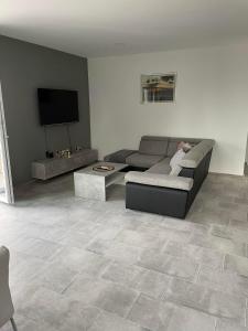 a living room with a couch and a flat screen tv at Apartman Ivanica in Lukoran