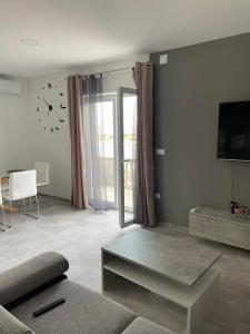 ein Wohnzimmer mit einem Sofa und einer Uhr an der Wand in der Unterkunft Apartman Ivanica in Lukoran