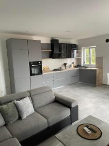 a living room with a couch and a kitchen at Apartman Ivanica in Lukoran