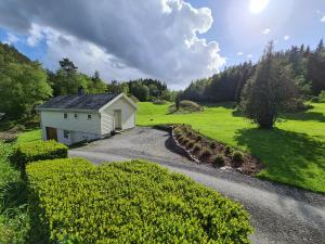 ein kleines weißes Gebäude auf einer Straße auf einem Feld in der Unterkunft Ropeid Fjordferie in Ropeid