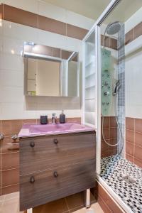 La salle de bains est pourvue d'un lavabo rose et d'une douche. dans l'établissement Studio Moderne & Cosy Proche Paris, à Rosny-sous-Bois