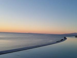 una piscina a sfioro con vista sull'oceano sullo sfondo di Cali Mykonos a Kalafatis
