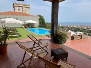 a patio with two chairs and a swimming pool at Villa Leucatia in Sant’Agata Li Battiati 