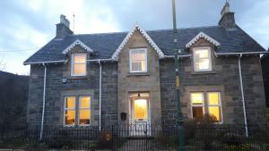 a brick house with a light on the door at Gynack Villa in Kingussie