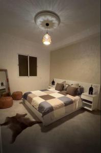 a bedroom with a large bed and a chandelier at Tiwaline Tarsime App C in Sidi Ifni