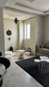 un salon avec un canapé et un tapis dans l'établissement Tiwaline Tarsime App C, à Sidi Ifni