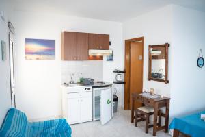 eine kleine Küche mit Spüle und Tisch in der Unterkunft Daisy's room in Archangelos