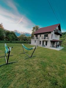 dwa krzesła na polu przed domem w obiekcie Transylvania Mountain View CDI w mieście Bran