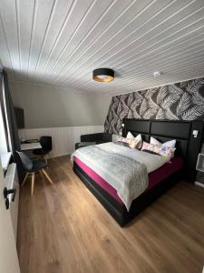 een slaapkamer met een groot bed en een wit plafond bij Pension Triebischtal in Meißen