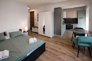 1 dormitorio con cama, mesa y cocina en Studio apartment above promenade w terrace & parking, en Rabac