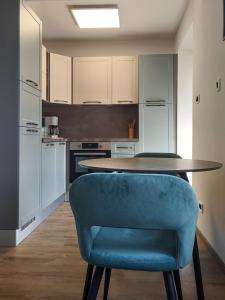cocina con mesa y silla azul en Studio apartment above promenade w terrace & parking, en Rabac