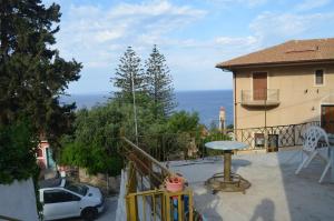 a balcony of a house with a car and a table at Nick Apartment in Zakynthos