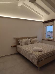 Cama en habitación blanca con ventana en Agriturismo Corte Acconi, en Mantua