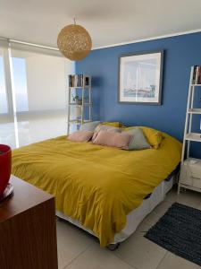 - une chambre avec un grand lit et une couverture jaune dans l'établissement Loft Reñaca On, à Viña del Mar