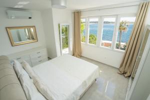 a bedroom with a bed and a large window at Villa Lucini Dvori in Novalja