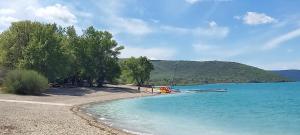 a boat sitting on the shore of a beach at le studio du lac in Les Salles-sur-Verdon