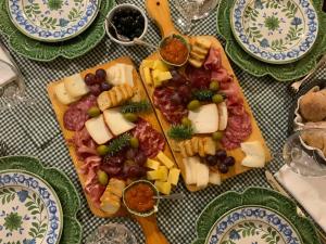 a table topped with plates of food with cheese and grapes at Charming Antas House in Porto