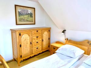 a bedroom with a wooden cabinet and a bed at Domek Maria Mąka in Zakopane
