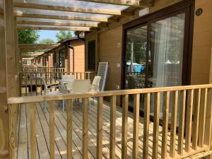 a deck with glass doors and a table and chairs at Camping Viareggio in Viareggio