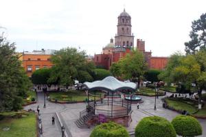 a park in a city with a building in the background at Hotel Plaza Queretaro in Querétaro
