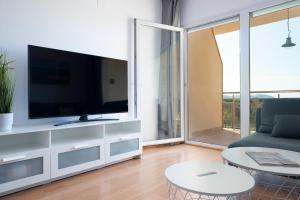 V016 - SUN VILLAGE في Palau-Saverdera: غرفة معيشة مع تلفزيون وأريكة وطاولة