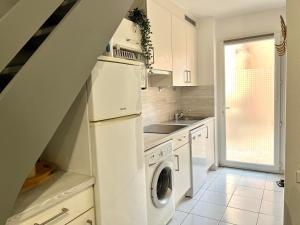 a kitchen with white cabinets and a washer and dryer at BARCARESA-Villa de Louis piscine vue mer, Lydia et plage in Le Barcarès