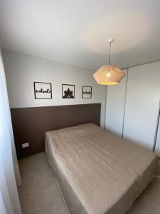 a bedroom with a bed and three pictures on the wall at Dptos equipados Gaudard in Río Cuarto