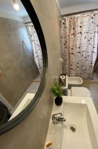 a bathroom with a sink and a mirror and a tub at Dptos equipados Gaudard in Río Cuarto