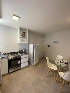 a kitchen with a stove and a table and chairs at Dptos equipados Gaudard in Río Cuarto