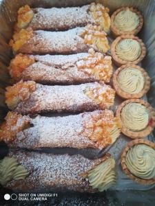 un vassoio di prodotti da forno e cupcake con zucchero in polvere di Le piante di casa SaMar a Castelguelfo