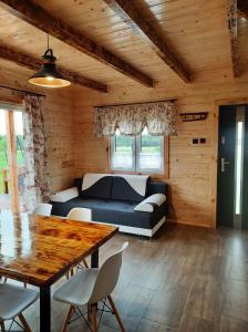 a living room with a couch and a table at Samosiejka - z widokiem na jezioro in Lidzbark