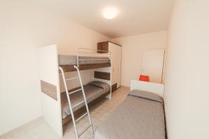 um pequeno quarto com beliches e uma escada em Residence Nova Marina em Sottomarina