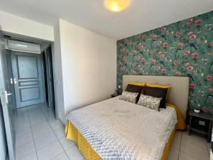 a bedroom with a bed with a floral wall at BARCARESA-Villa de Louis piscine vue mer, Lydia et plage in Le Barcarès +20 photos