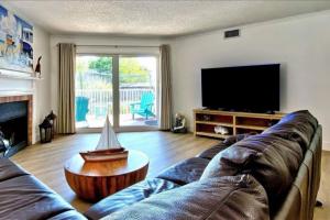 a living room with a couch and a flat screen tv at Beach Cottage 1104 in Clearwater Beach
