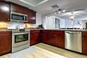 a kitchen with wooden cabinets and stainless steel appliances at Beach Cottage 1104 in Clearwater Beach