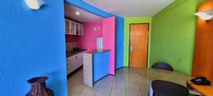 cocina con paredes coloridas, mesa y sillas en Praia Mansa Flat, en Fortaleza