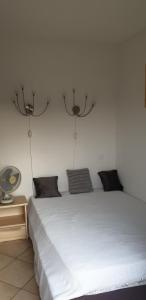 sypialnia z białym łóżkiem i wentylatorem w obiekcie Très bel appartement,proche plage et centre ville. w Calvi