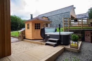 um quintal com uma banheira de hidromassagem e um barracão em Brecon View Eco Village em Garnant