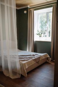 Bett in einem Zimmer mit Fenster und Vorhang in der Unterkunft Hubane korter Viljandi vanalinnas in Viljandi