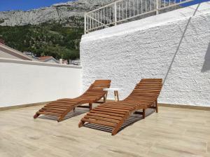 two wooden chairs and a table on a balcony at Private bedroom with bathroom in Baška Voda
