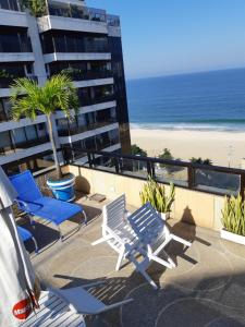 a balcony with chairs and a beach and a building at Oceano Copacabana Hotel in Rio de Janeiro