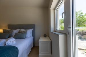 a bedroom with a bed and a window at Green Apartment Pedras Salgadas in Pedras Salgadas