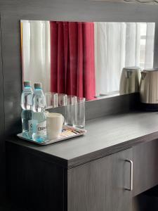 a counter with two bottles of water and a tray of glasses at Apartamenty Centrum in Olkusz