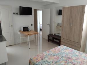 a bedroom with a bed and a table and a desk at Edificio Triana St 47 in Las Palmas de Gran Canaria