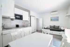 een witte keuken en een woonkamer met een bank bij The bell tower apartment - Bellagio center in Bellagio