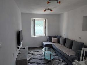 a living room with a couch and a glass table at Apartment Rosić in Perast