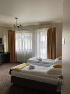 a hotel room with two beds and a window at Apartamenty Centrum in Olkusz
